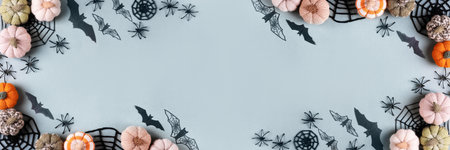 Happy Halloween holiday concept. Frame made of Halloween decorations, spiders, bats, knitted webs, pumpkins on green background. Flat lay, top view, bannerの写真素材