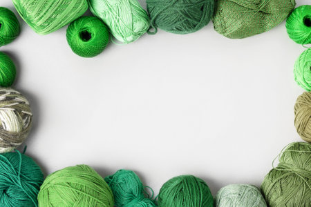 Creative layout made of green threads for knitting on a gray background with place for your text. Flat lay. Hobby needlework knitting. Concept Do it yourselfの写真素材