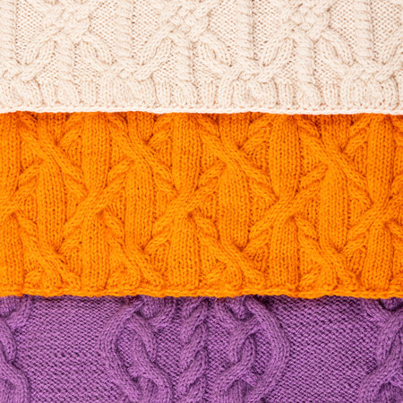 Color abstract knitted background. Large knitted fabric with a pattern. Close-up of knitted blanket.