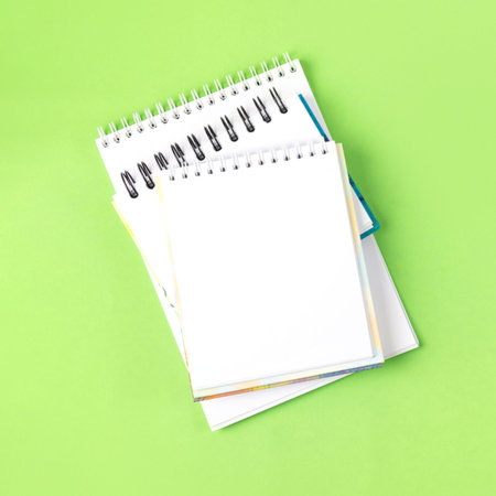 Opened blank notepad on green background. Festive office desktop concept.