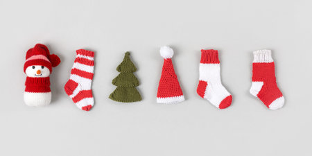 Knitted Christmas toys snowman in a red hat, red and white socks, Santa Claus hat, green Christmas...