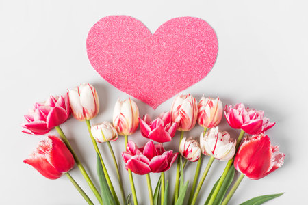 Spring composition on gray background of flowers pink and white tulips with pink heart shape made of paper for text. Happy Mothers Day greeting card, happy Valentines Day, March 8, happy birthdayの写真素材