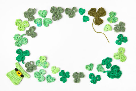 St Patricks Day concept. Composition made of knitted green shamrocks and hat on a gray background. Holiday sign and knitted clover leaf. Copy space, flat lay, place for textの写真素材