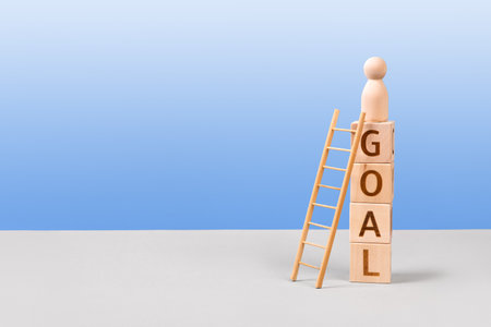 Wooden cubes with the words goal and wooden ladders are a symbol of success, business progress, strategic development of a company, startup. Business conceptの写真素材