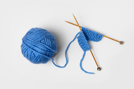 Blue knitted wool on gray background with knitting needles for knitting warm clothes and hobbies...