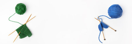 Green and blue knitted wool on gray background with knitting needles for knitting warm clothes and hobbies needlework. Banner, flat lay, copy spaceの写真素材