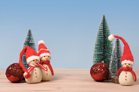 Christmas background with knitted snowmen in red hats and Christmas trees with red ball and space for text, greetings, promotions, and discounts. Christmas and New Year card.の写真素材