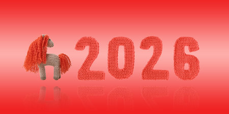 Crocheted toy fiery red horse and knitted green numbers. The symbol of the year 2026 on a red background. Chinese New Year greeting cardの写真素材