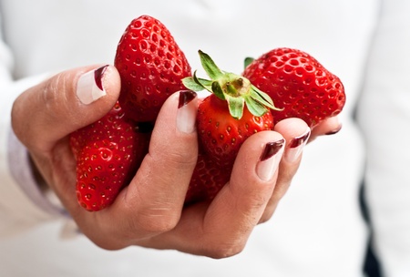 Woman s hand with strawberriesの写真素材