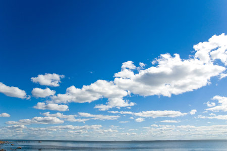White clouds on blue sky. Sea.