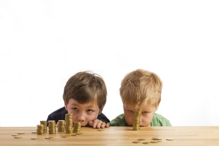 Boys looking at towers of moneyの写真素材
