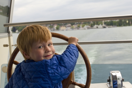 Young boy steering a shipの写真素材