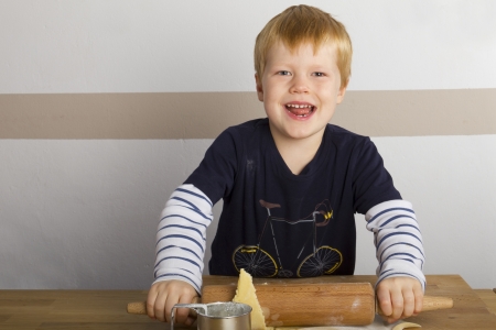 Boy rolls out doughwith a rolling pinの写真素材