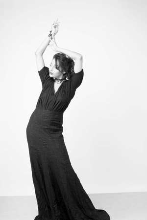 beautiful female model in fashionable black gown in front of a solid backgroundの写真素材