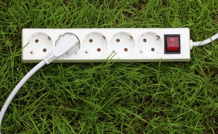 electric power receptacle and plug on the grass, energy conceptの写真素材