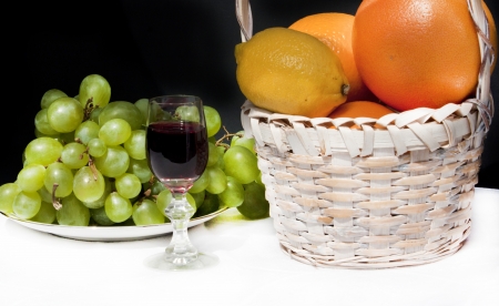 Glass of red wine ang grapes and orangesの写真素材