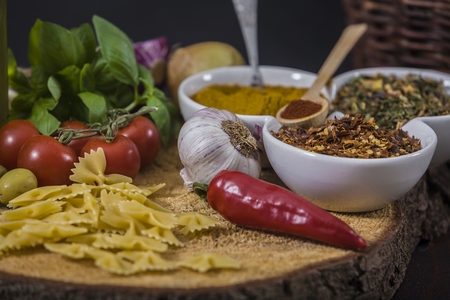 tomatoes, basil and spices on dark grunge backdropの写真素材