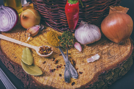 assorted spices on wooden background, obion, garlic, pepper, curryの写真素材