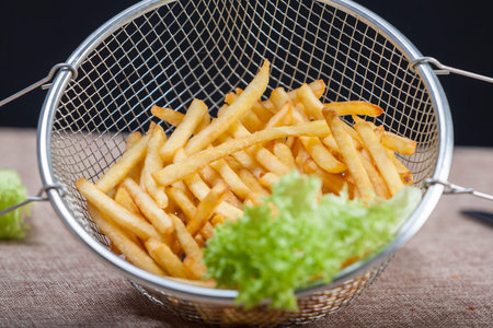 Fresh fried french fries with ketchup on wooden background