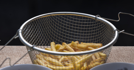 Fresh fried french fries with ketchup on wooden backgroundの写真素材