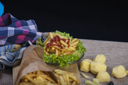 Fresh fried french fries with ketchup on wooden backgroundの写真素材