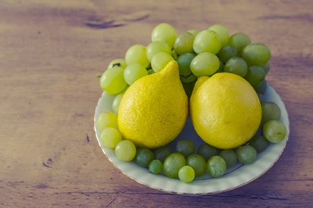 grapes and lemons on a plateの写真素材