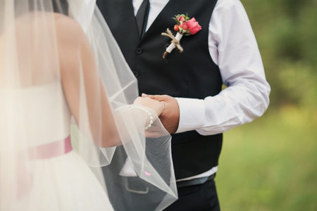 The groom holds the hand of his beautiful bride before the wedding processの写真素材