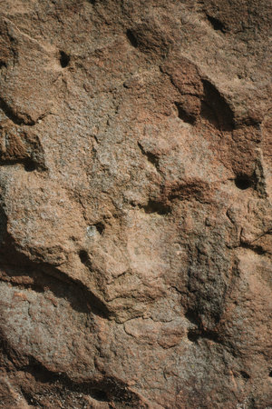 Light gray stone texture with different patterns, cracks, protrusions shadows and holes. Background...
