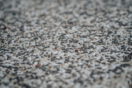 Backgrounds from a large number of multi-colored pebbles in the sand. A lot of stones close-up with...