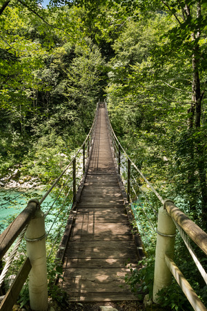 Wooden footbridge over river Soca near Kobaridの写真素材