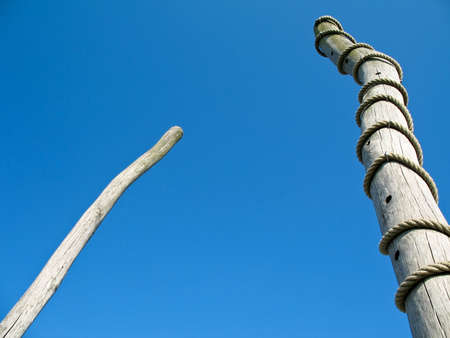 two wooden boles, one surrounded by cordの写真素材