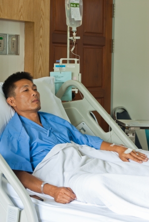 a patient with saline intravenous  iv  on hospital bedの写真素材