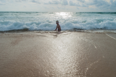 Playful Asian boy on the beach with sea on background at Phuket island,Thailandの写真素材