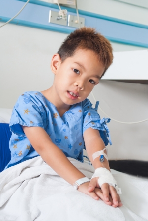 Asian patient boy with saline intravenous  iv  on hospital bed の写真素材