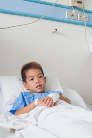 Asian patient boy with saline intravenous  iv  on hospital bed の写真素材