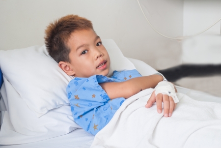 Asian patient boy with saline intravenous  iv  on hospital bed の写真素材