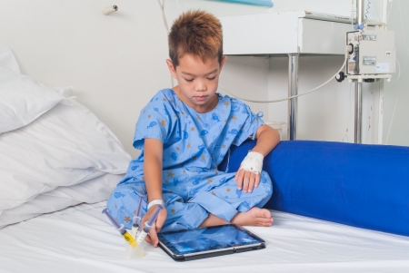Asian patient boy with saline intravenous  iv  on hospital bed の写真素材