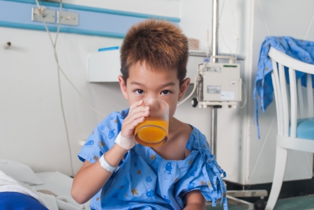 Asian patient boy with saline intravenous  iv  on hospital bed  Are eating medicines の写真素材
