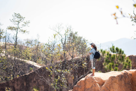 Outdoor summer smiling lifestyle portrait of pretty young woman having fun in mountain view in the north of Thailand  with camera travel photo of photographer Making pictures in hipster style.の写真素材