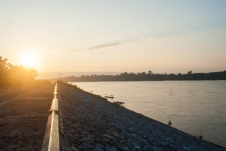 Sun rise on Mekong river with mountain and cloudy sky and tree from NongKai,Thailandの写真素材