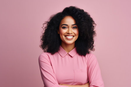 Portrait of smiling african american woman in pink shirt on pink backgroundの素材
