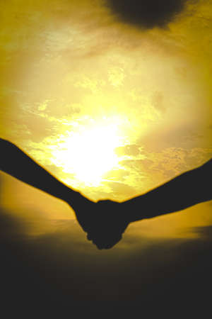 silhouette of friends holding handsの写真素材