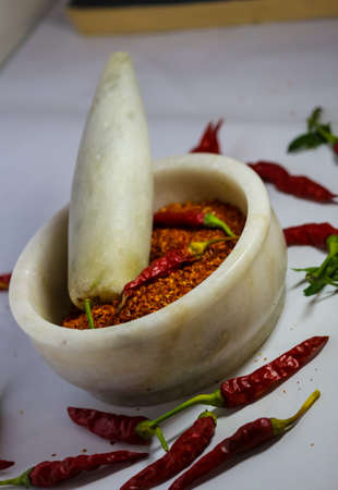Red chillies and red chilli powder in the pestle mortarの写真素材