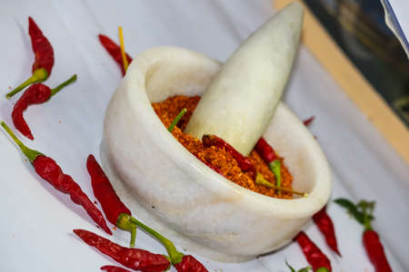 red hot chilli peppers and red chilli powder in the motor pestleの写真素材