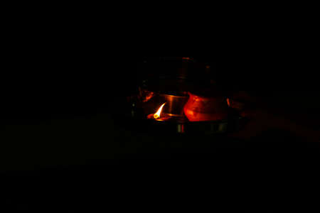 A glowing candle on the black background Halloween, diwali, Christmas, festival, newyearの写真素材