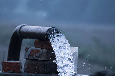 Water running out of the pipeline to water the fields in the morningの写真素材