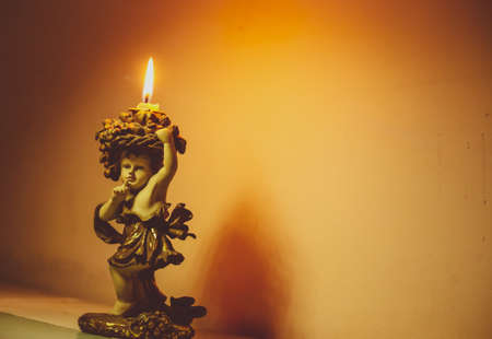 Glowing candle on a cute candle standの写真素材