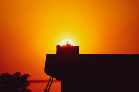 silhouette of a rooftop with a tank at sunsetの写真素材