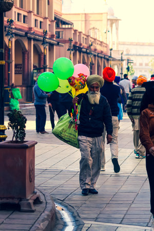 an old man selling balloons walking on the streetのeditorial素材