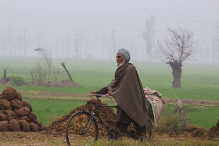 A farmer with a bicycle in his farmsのeditorial素材